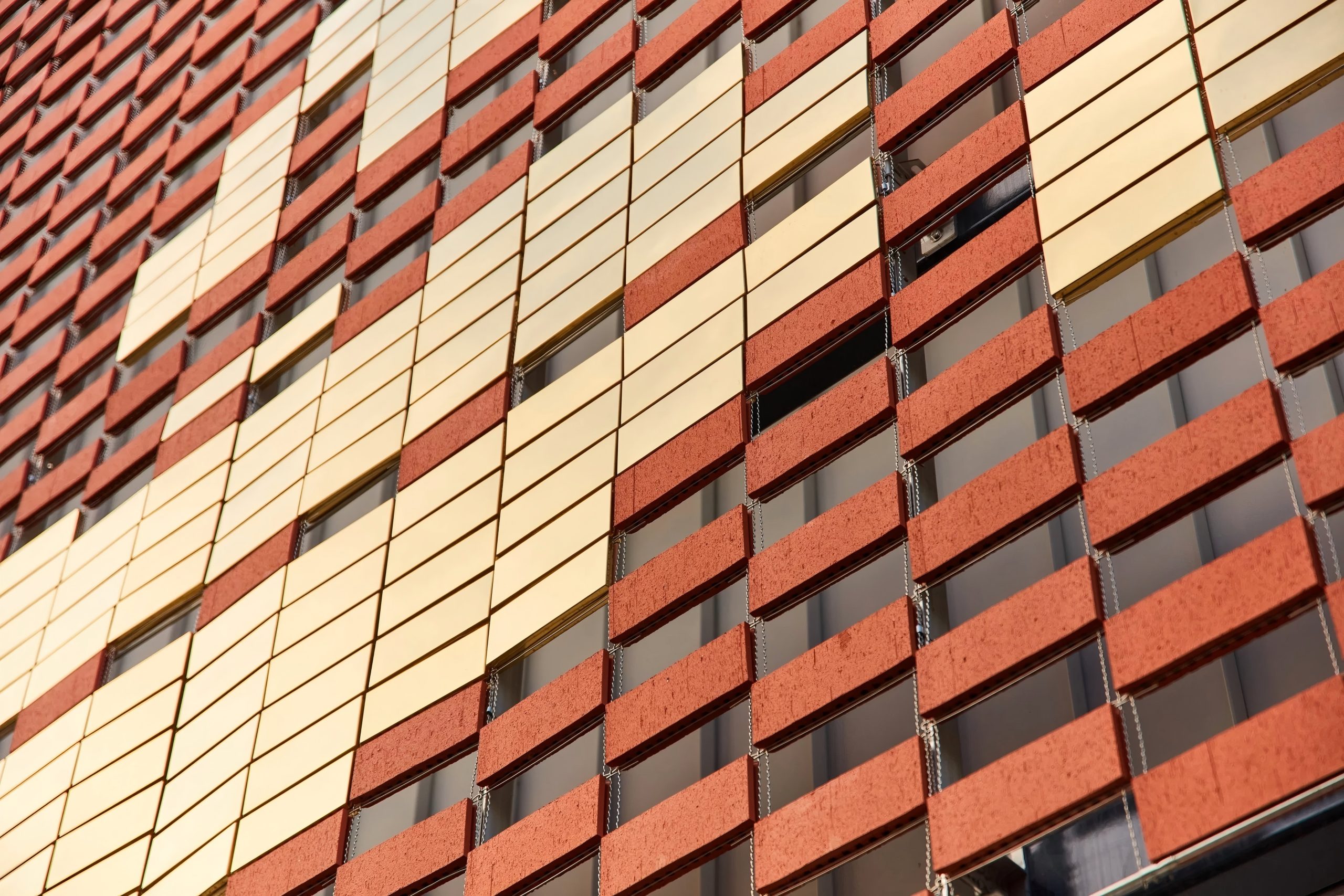 Corium brick cladding system with various colored clay tiles on steel rails